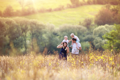 Family walking through fields in the sunlight